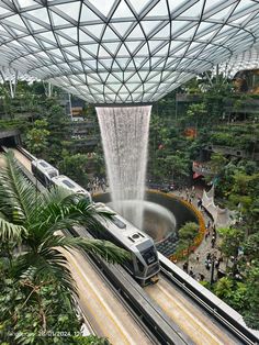 a train on the tracks in an indoor area with water spraying from it's roof