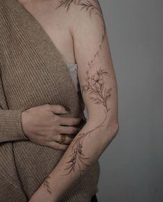 a woman with a flower tattoo on her left arm and right arm behind her back