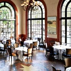 an empty restaurant with tables and chairs in front of large windows