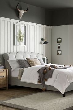 a bedroom with gray walls and white bedding