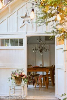 an open door to a white house with chandelier hanging from the ceiling