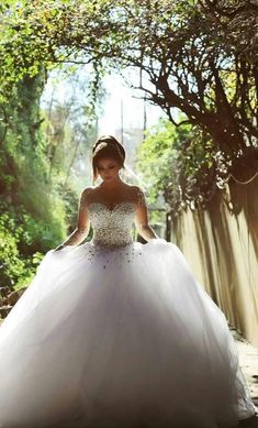 a woman in a wedding dress is posing for the camera