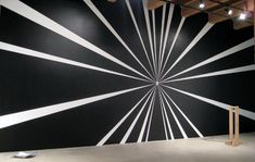 a large black and white wall with lines painted on it's side in an empty room