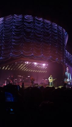 the band is performing on stage in front of an audience