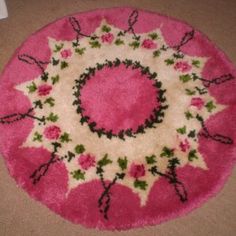 a pink rug with black and white designs on the bottom is laying on the floor