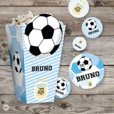 a blue and white popcorn box with soccer balls on it, surrounded by stickers