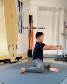 a man sitting on a yoga mat in a room