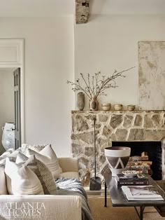 a living room filled with furniture and a fire place in front of a stone fireplace