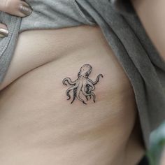 an octopus tattoo on the side of a woman's stomach is seen in this image