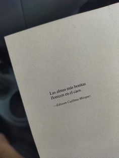 a person holding up a book with a quote on it