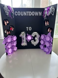 a table with balloons and decorations on it for a 13th birthday party in the shape of flowers