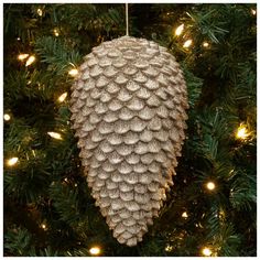 a pine cone ornament hanging from a christmas tree