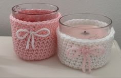 two crocheted jars sitting next to each other on top of a white table