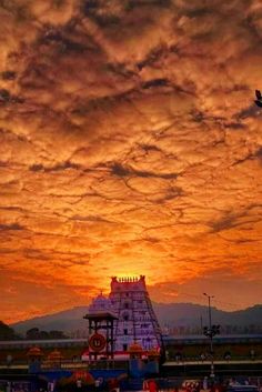 the sun is setting over an amusement park