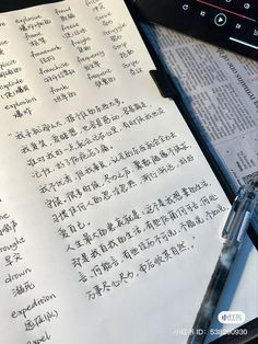 an open book sitting on top of a table next to a pen