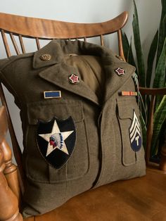 an army uniform pillow sitting on top of a wooden chair