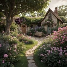 a garden with flowers and a bench in front of a small house that is surrounded by trees