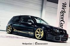 a black car with gold rims parked in a garage