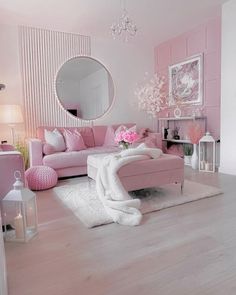 a living room filled with pink furniture and white rugs on top of a hard wood floor