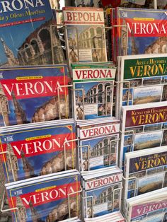 many magazines stacked on top of each other in front of a store display case,