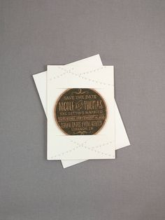 two wedding save the date magnets on top of each other next to some paper