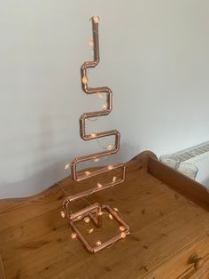 a metal sculpture sitting on top of a wooden table