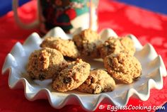 cookies on a white plate next to a jar of cocoa butter and a red tablecloth