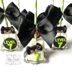 there are seven cake pops decorated with black bows and the number seven on each one