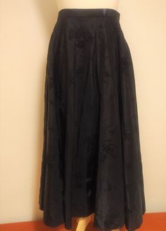 "A sweet 1950s black circle skirt. Made of black devore satin. Pattern is black sprigs of what looks like a grape print. There is a label inside near the waistband but its not readable and is probably the name of the maker.   Probably hand made. Fastens with an invisible zip and hook and eye. Unlined. The original owner has inserted an extra panel at the top of the waistband for some extra room! We have measured it flat. Our mannequin is a UK size 10. Although probably a better fit size 8. Waist is 25\". Hips full! Length from waistband to hem 31\". Superb condition! We deliver worldwide and have listed postage and delivery for countries in Europe and worldwide. Please message us for postage costs if your country of residency has not been listed and you are interested in purchasing this it 1950s Circle Skirt, Black Circle Skirt, Satin Pattern, Black Circle, Extra Rooms, Invisible Zip, The Maker, Extra Room, Hook And Eye