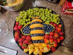 a platter filled with fruits and vegetables on top of a counter