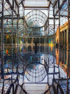 the inside of a building with lots of glass and metal structures on it's sides