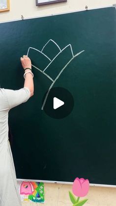 a woman writing on a blackboard in front of a chalk board with a crown drawn on it