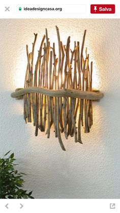 a light that is on the wall with some branches hanging from it's side