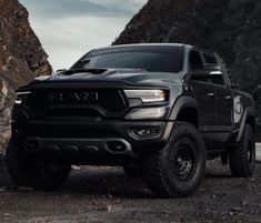 a black ram truck parked in front of some rocks