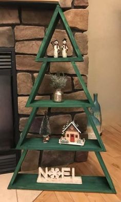 a christmas tree made out of wooden shelves in front of a fire place with decorations on top