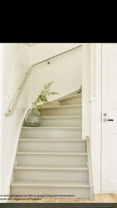 there is a vase with some flowers on the top of it at the bottom of stairs