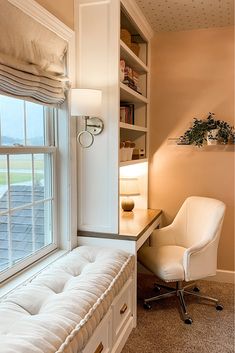 a room with a window, desk and white chair in front of a book shelf