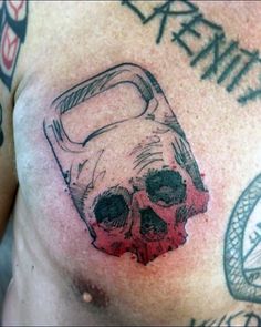 a close up of a person's chest with tattoos on it and a skull in the middle