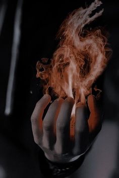 a person holding out their hand with fire in it