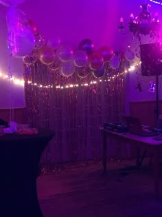 the room is decorated with balloons, streamers and disco lights for an event or party