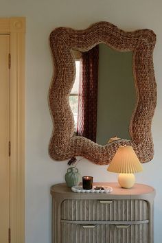 a dresser with a mirror and lamp on it