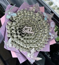 a bunch of rolled up money sitting in the back of a car with happy birthday written on it