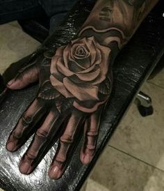 a hand with a rose tattoo on it