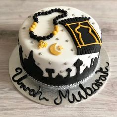 a white and black cake with gold decorations