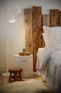 a white bed sitting next to a wooden headboard