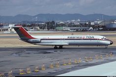 an airplane that is sitting on the tarmac with mountains in the backgroud