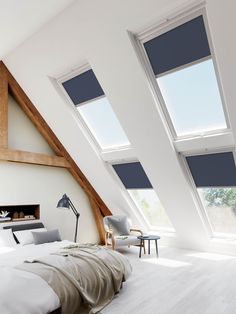 an attic bedroom with skylights and white walls