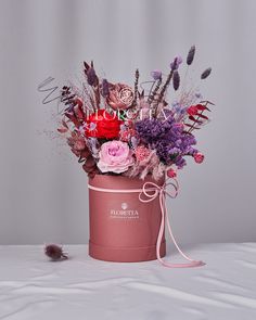 a pink hat box filled with lots of flowers