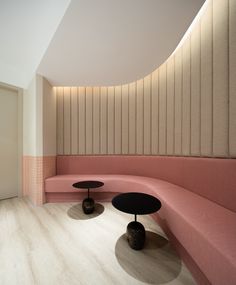 a pink couch and two black tables in a room