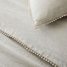 two pillows on top of each other with scalloped edges and trimmings